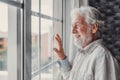 Happy thoughtful older 70s man looking out of window away with hope, thinking of good health, retirement, insurance benefits, Royalty Free Stock Photo