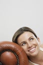 Happy Thoughtful Woman Relaxing On Sofa's Armrest Royalty Free Stock Photo