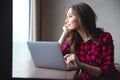 Happy thoughtful woman using laptop computer