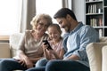 Happy three family generations using modern smartphone