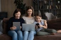 Happy three female generations family using different gadgets. Royalty Free Stock Photo