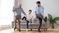 Happy three generation men family dancing together in living room