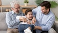 Happy three generation men family playing laughing tickling on sofa Royalty Free Stock Photo