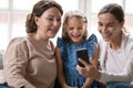 Happy three generations of women have fun using cellphone Royalty Free Stock Photo