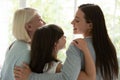 Happy three generations of women hug showing unity