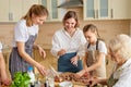 Happy three generations of women preparing cooking pizza, standing in kitchen Royalty Free Stock Photo