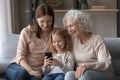 Happy three generations of women use cellphone together Royalty Free Stock Photo