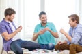 Happy three male friends playing poker at home Royalty Free Stock Photo