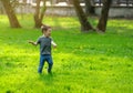 Happy three year old toddler boy having fun and running on green grass in the park on a sunny summer or spring day Royalty Free Stock Photo