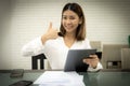 Happy thumbs up asian office girl doing good online sales on her tablet for bussiness Royalty Free Stock Photo