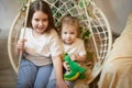 Happy time concept. Girls Sisters in chair and having fun. Female Preschooler and teenager playing relaxing in room