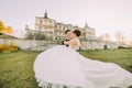 Happy time spending in the gothic castle. The groom is carrying the bride. The back view of the bride. Royalty Free Stock Photo