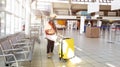 Happy time young tourist woman holding the luggage and watching the flight and sunlight through window in Airport terminal