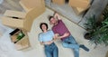 Happy but tired young couple lie on the floor of their new home. Young couple lying on floor of their new apartment in Royalty Free Stock Photo