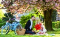Happy to be in love. romantic couple on picnic. love date in spring. relax under blooming sakura. couple in love