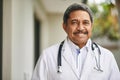 Happy to help you recover. Portrait of a mature male doctor standing outside. Royalty Free Stock Photo