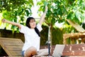 work Cheerful young Asian woman smiling while working on her laptop outside the office, at home, working in the park. Royalty Free Stock Photo