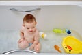 Happy toddler baby boy is playing with toys in the bathtub. A child play Royalty Free Stock Photo