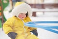 Happy toddler baby boy rides a carousel on a winter playground. A chil Royalty Free Stock Photo