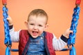 Happy toddler baby boy rides on a swing. Smiling child swinging on the Royalty Free Stock Photo