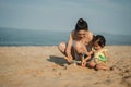 happy toddler baby girl playing sand toy with mother on the sea beach Royalty Free Stock Photo