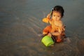 happy toddler baby girl playing toy and water on sea beach Royalty Free Stock Photo