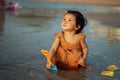 happy toddler baby girl playing toy and water on sea beach Royalty Free Stock Photo