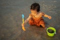 happy toddler baby girl playing toy and water on sea beach Royalty Free Stock Photo