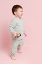 Happy toddler baby is playing with a toy car against a pink background Royalty Free Stock Photo