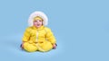 Happy toddler baby in winter clothes snowsuit on studio blue backgrou