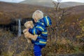 Happy toddler child, holding teddy bear, posing in front of beautiful waterfall Svartifoss in Skaftafell national park in Iceland Royalty Free Stock Photo