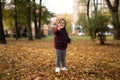 Happy toddler child plays with yellow leaves on sunny autumn day Royalty Free Stock Photo