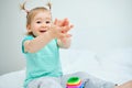 Happy toddler claps his hands on the bed Royalty Free Stock Photo