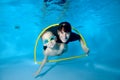 A happy toddler and a female trainer swim together underwater through a Hoop. They smile and look at the camera. Active Royalty Free Stock Photo