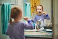 Happy toddler girl in pyjamas brushing her teeth in bathroom in the morning or before going to sleep Royalty Free Stock Photo