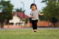 happy toddler girl running on grass field in park Royalty Free Stock Photo
