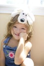 Happy toddler girl with toy dog over head