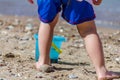 Happy Toddler Kid Play with his Bucket on the Sundy Beach. Boy Fills the Bucket with Water and Sand. Child Plays by the Sea Royalty Free Stock Photo