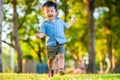 Happy toddler little boy first running on green grass field sunset light Royalty Free Stock Photo