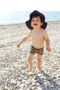 Happy toddler running along the pebbles beach