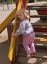 Happy toddler shouting on the wooden slide steps