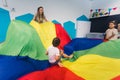 Happy toddlers having an active sensory play with texture and colors at the nursery school. Kids wellness. Early fine