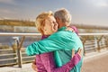 Happy together. Active mature family couple in sportswear embracing after having workout in the city park on a sunny Royalty Free Stock Photo