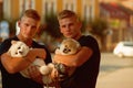 Always happy together. Muscular men with dog pets. Happy family on walk. Twins men hold pedigree dogs. Happy twins with