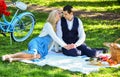 Happy together. Picnic time. Spring date. Playful couple having picnic in park. Romantic picnic. Couple cuddling on