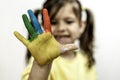 Happy toothless little girl with the five number painted on the hand laughing and having fun - Little girl who is painting her Royalty Free Stock Photo