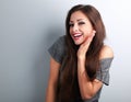 Happy toothy laughing brunette young woman with hand near face Royalty Free Stock Photo