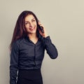 Happy toothy smiling young positive woman with long curly hairstyle in business office clothing talking on mobile phone and Royalty Free Stock Photo