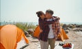 Happy tourist couple embracing and kissing. Romantic camping weekend on seashore