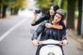 Happy tourist young couple on scooter ride in new city. Woman making photo on camera while riding outdoors Royalty Free Stock Photo